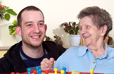 Seniorin mit Pfleger bei Mensch ärgere dich nicht