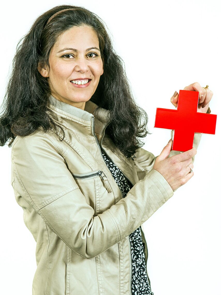 Frau hält Rotes Kreuz in zwei Händen