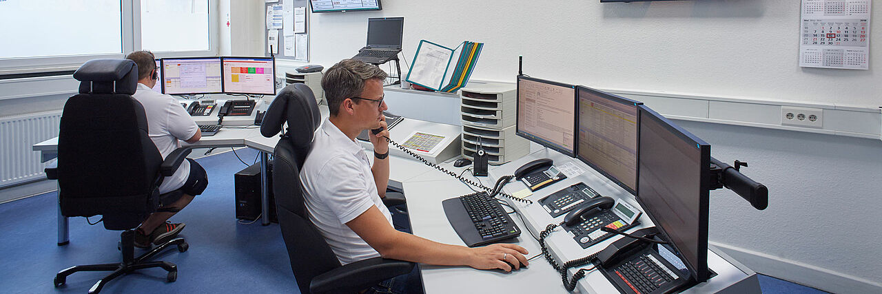 Einsatzleitzentrale, zwei Männer mit Telefonen am Computer