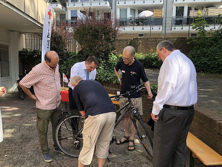 Männer reparieren Fahrrad aus der DRK Fahrradwerkstatt
