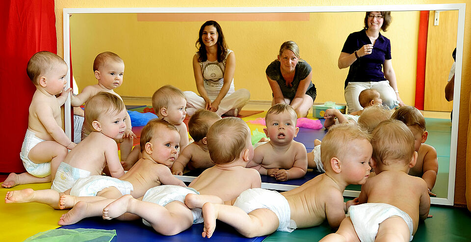 mehrere Babys auf Teppich bei Familienbildung