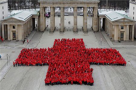 Rotes Kreuz aus Menschen vor dem Brandenburger Tor