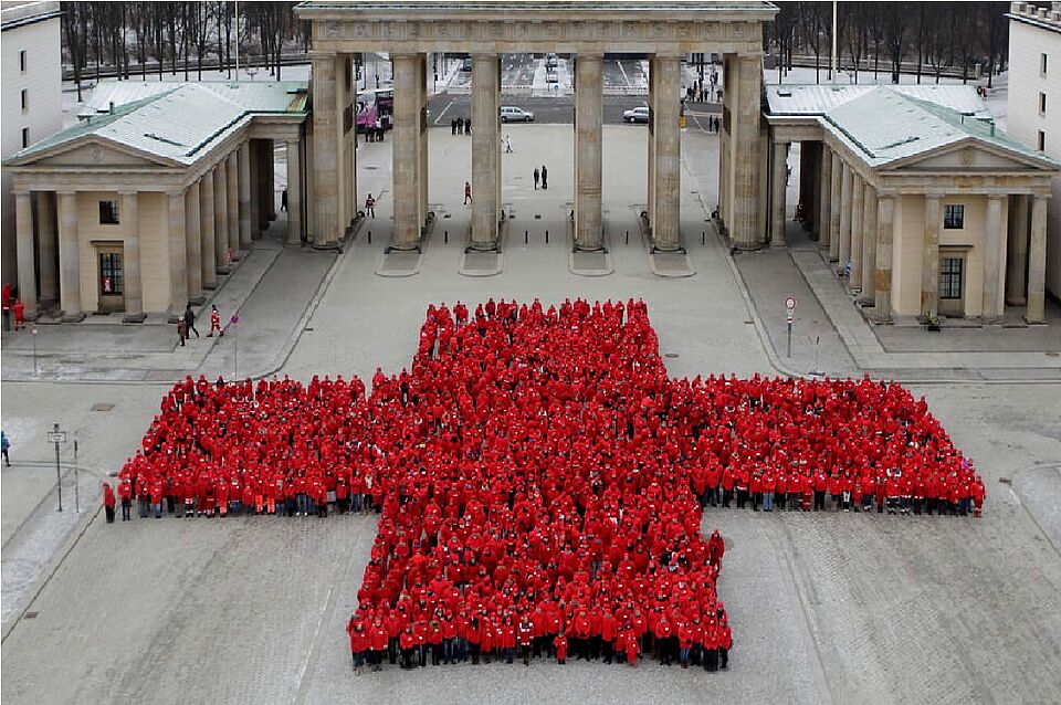 Rotes Kreuz aus Menschen vor dem Brandenburger Tor