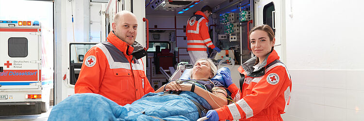 lächelnde Sanitäter mit Patientin