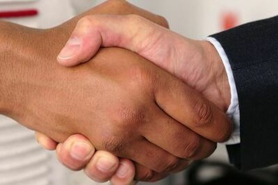 zwei Personen schütteln sich die Hände